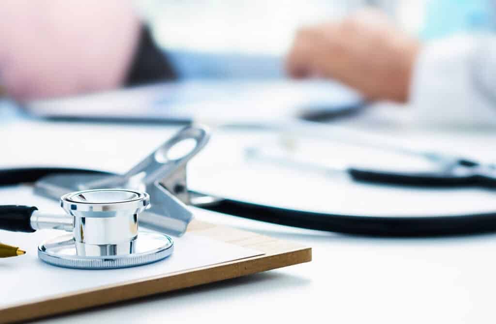 Stethoscope and clip board on the doctors workplace close-up