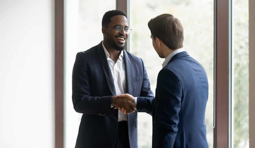 Overjoyed businessmen shake hands